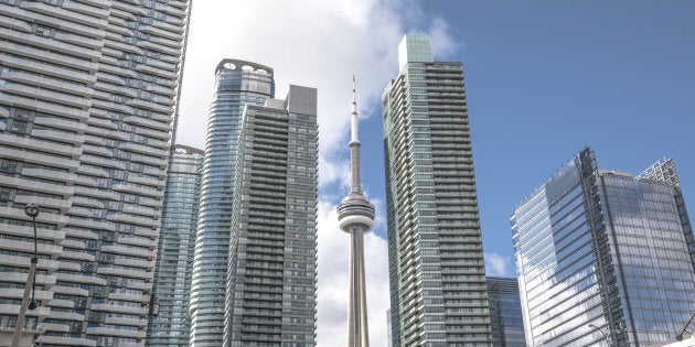 The CN Tower peaks out from behind condos along Toronto's lake shore. Prices for new condos in the city have soared even as sales have dropped by nearly two-thirds.