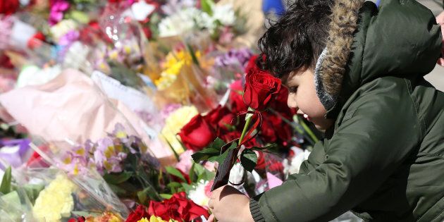 A boy leaves a rose at a memorial in Mel Lastman Square ahead of a vigil for the van attack victims, in North York, Ont. on Sunday.