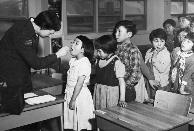 A nurse checking a girl's throat at the segregated Frobisher Bay Federal Hospital in Iqaluit, Nunavut, in a 1959 archive photo.