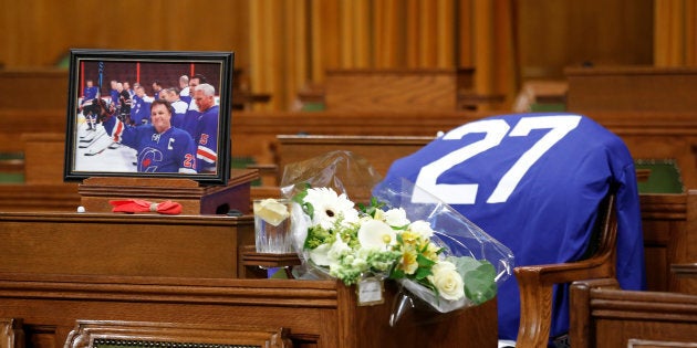 Flowers, a photograph and a hockey jersey are seen at the desk of the late Conservative MP Gord Brown, who died Wednesday, in the House of Commons on May 2, 2018.