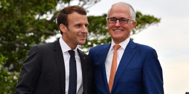 French President Emmanuel Macron embraces Australian Prime Minister Malcolm Turnbull (R) at the end of a joint press conference in Sydney on May 2, 2018.