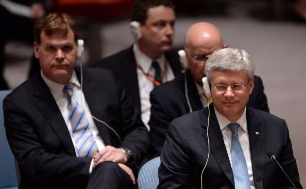 Stephen Harper, right, waits to speak at the UN Security Council at the United Nations in New York on Sept. 24, 2014. John Baird is seated behind.
