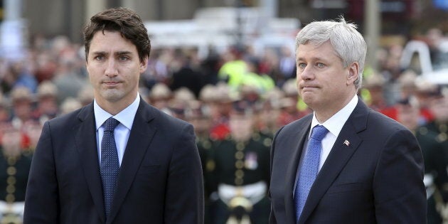 Stephen Harper and Justin Trudeau pause after laying a wreath during a ceremony to commemorate the October 2014 attack on Parliament Hill, at the National War Memorial in Ottawa on Oct. 22, 2015.