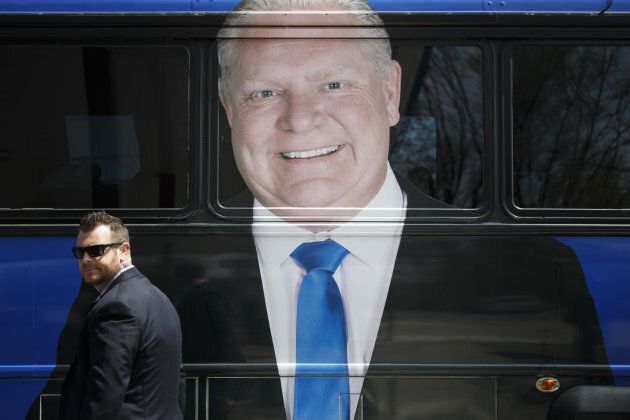 A security guard stands outside of the campaign bus for Doug Ford, Progressive Conservative Party candidate for Ontario Premier, during a press conference in Oakville, Ontario, on May 16.