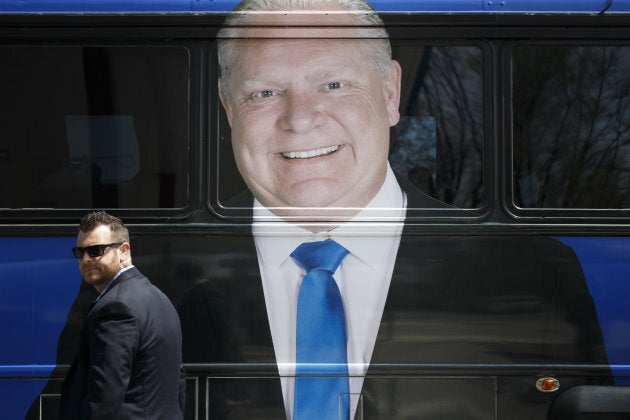 A security guard stands outside of the campaign bus for Doug Ford, Progressive Conservative Party candidate for Ontario Premier, during a press conference in Oakville, Ontario, on May 16.