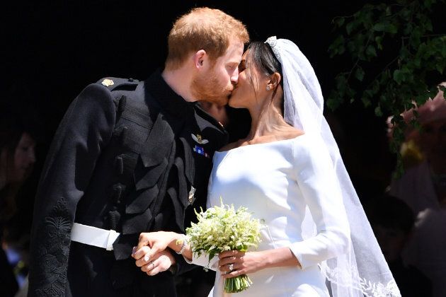 Prince Harry kisses his wife Meghan as they leave from the West Door of St George's Chapel, Windsor Castle, in Windsor on May 19, 2018.