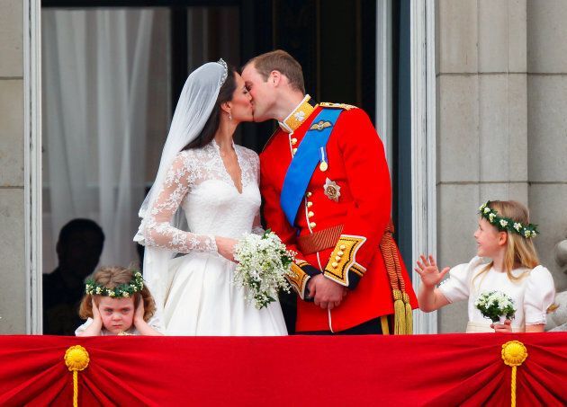 Prince William and Kate Middleton kiss on the balcony of Buckingham Palace.
