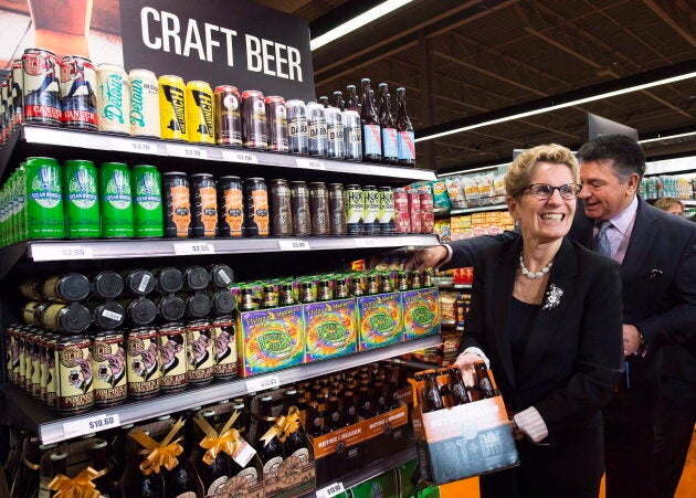 Ontario Premier Kathleen Wynne, left, and Minister of Finance Charles Sousa, right, pick beer at a Loblaws grocery store in Toronto on Dec. 15, 2015.