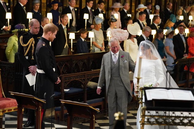 Prince Harry looks at his bride, Meghan Markle, as she arrives accompanied by Prince Charles, Prince of Wales during their wedding.