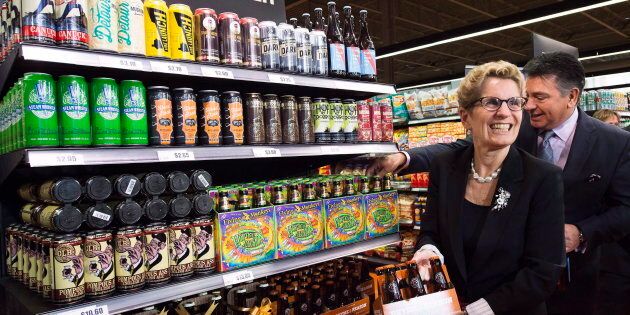 Ontario Premier Kathleen Wynne, left, and Minister of Finance Charles Sousa, right, pick beer at a Loblaws grocery store in Toronto on Dec. 15, 2015.