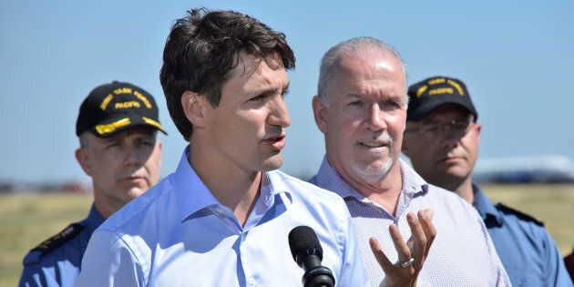 Prime Minister Justin Trudeau, accompanied by British Columbia's Premier John Horgan, addresses the media after touring areas affected by wildfires in Williams Lake, B.C. on July 31, 2017.