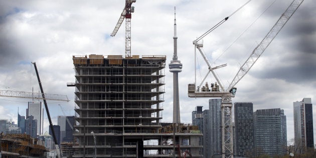 The CN Tower stands behind a condominium building under construction in Toronto on May 10. New home sales in Greater Toronto have seen their worst April this century, and possibly the worst since the housing slump of the 1990s.