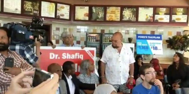 Ontario Liberal candidate Shafiq Qaadri appeared at an NDP press conference holding one of his campaign signs.
