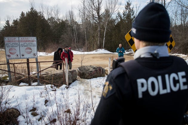 A couple claiming to be from Turkey is warned by a Royal Canadian Mounted Police officer before they cross the U.S.-Canada border into Canada on Feb. 23, 2017 in Hemmingford, Que.