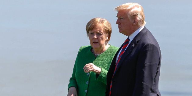 Germany's Chancellor Angela Merkel talks with U.S. President Donald Trump at a family photo session with the leaders of the G7 summit in Charlevoix, Que.