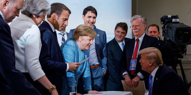 Prime Minister Justin Trudeau, British Prime Minister Theresa May, French President Emmanuel Macron, German Chancellor Angela Merkel, and U.S. President Donald Trump discuss the joint statement following a breakfast meeting at the G7 summit in La Malbaie, Que. on June 9, 2018.