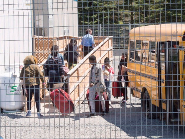 A group of asylum seekers arrive at the temporary housing facilities at the border crossing on May 9, 2018 in St. Bernard-de-Lacolle, Que.