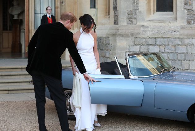 Prince Harry helps his new bride, the Duchess of Sussex, into the car as they leave Windsor Castle after their wedding to attend an evening reception at Frogmore House on May 19.
