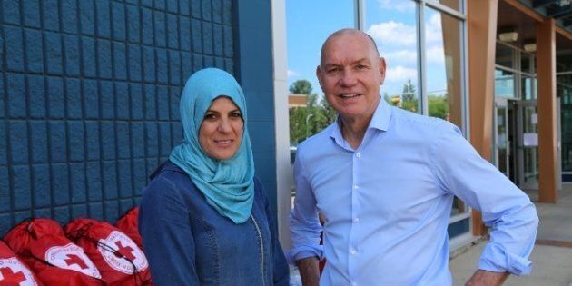 Canadian Red Cross President and CEO Conrad Sauvé with Fort McMurray resident and small business owner Rewaida Assaf.