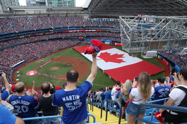 An overhead view of the Rogers Centre as a large Canadian flag is unfurled for Canada Day on July 1, 2017.