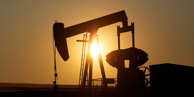 An oil pump jack pumps oil in a field near Calgary on July 21, 2014.