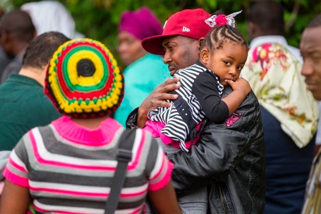 A long line of asylum seekers wait to cross the Canada-U.S. border near Champlain, N.Y. on Aug. 6, 2017.