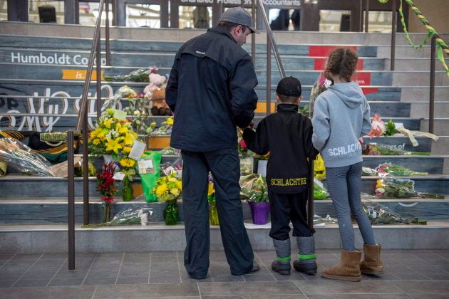 People gather at a memorial set up on the stairs that lead to Elgar Petersen Arena in Humboldt, Sask. on April 7, 2018.