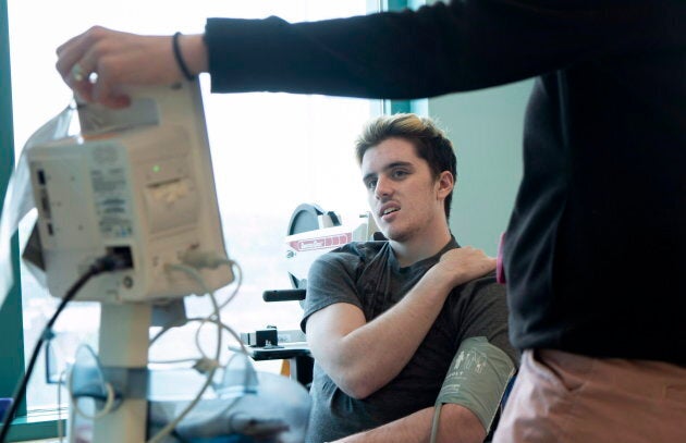 Humboldt Broncos survivor Ryan Straschnitzki has his blood pressure taken during a physiotherapy session at the Shriners Hospital in Philadelphia on June 25, 2018.