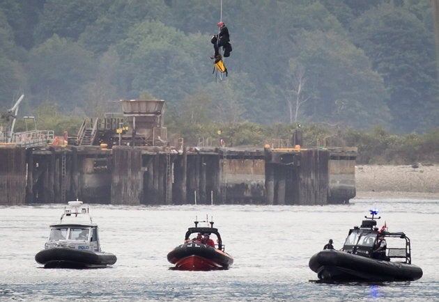 A protester opposed to the Kinder Morgan Trans Mountain Pipeline expansion is lowered to a police boat after spending two days suspended from the Second Narrows Bridge in Vancouver, on July 4, 2018.