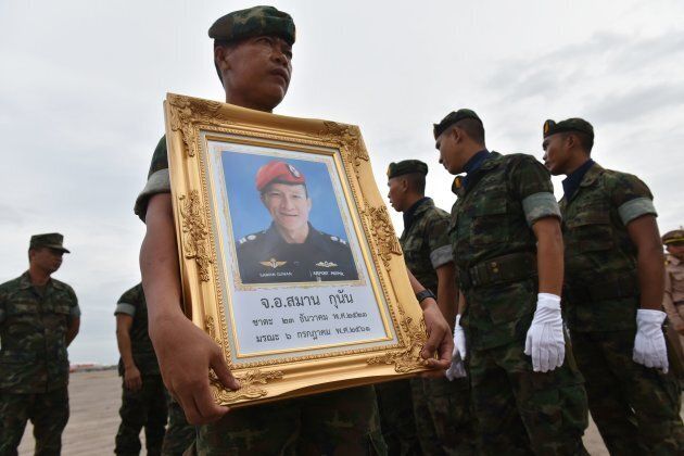 A Royal Thai Navy soldier carries a portrait of Saman Gunan, a former navy SEAL who died in the Tham Luang cave rescue operation.