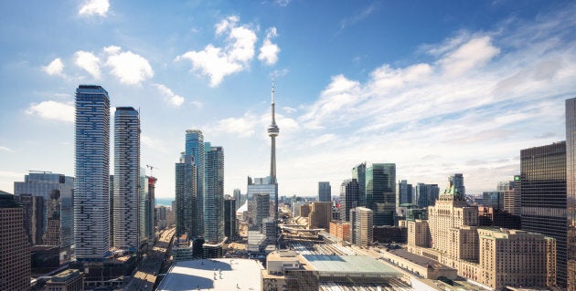 A high-resolution panoramic image of Toronto's city centre skyline, with the CN Tower in the centre.