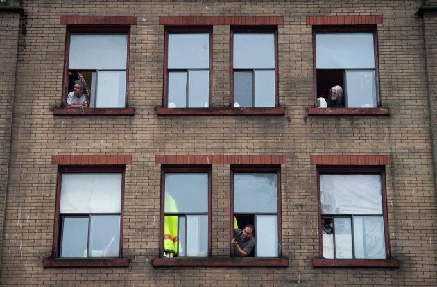 Residents of a single room occupancy hotel (SRO) watch from windows in the Downtown Eastside of Vancouver, B.C.