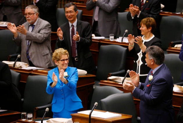 Ontario Premier Kathleen Wynne applauds Ontario Finance Minister Charles Sousa as the provincial budget is distributed at Queens Park in Toronto on May 1, 2014.