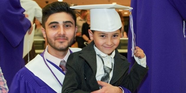 Yasser Al Asmi, 18, smiles with his younger brother at his graduation from Moncton High School.