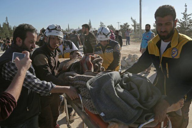 Syrian Civil Defence carry an injured man as Jaish al-Islam fighters and their families arrive from the former rebel bastion's main town of Douma at the Abu al-Zindeen checkpoint controlled by Turkish-backed rebel fighters near the northern Syrian town of al-Bab, on April 4, 2018.