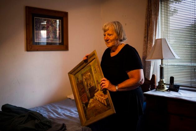 Elizabeth Hill pulls a painting off the wall in a guest room of her home in Toronto, on July 20, 2018.