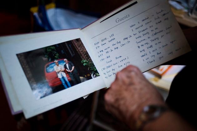 Elizabeth Hill looks through a guest book with notes from live-in students, in her home in Toronto, on July 20, 2018.
