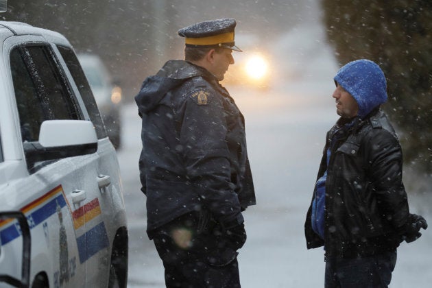 A man that claimed to be from Syria is detained by an RCMP officer after he crossed the U.S.-Canada border into Hemmingford, Que. on March 2, 2017.