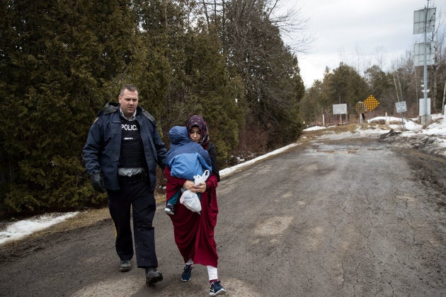 A mother and child from Turkey are escorted by RCMP after they crossed the U.S.-Canada border into Canada, Feb. 23, 2017.