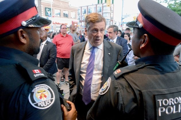 Toronto Mayor John Tory speaks to police officers at the scene following a mass shooting in Toronto on July 23, 2018. -