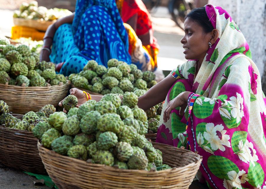 A woman sits at a roadside market in a Madhya Pradesh town in India.