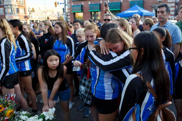 Friends of Julianna Kozis, one the victims of Sunday night's shooting on the Danforth, embrace during a vigil.