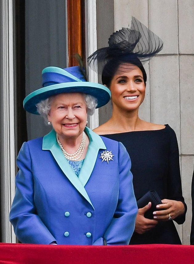 Queen Elizabeth ll and Meghan, Duchess of Sussex stand on the balcony of Buckingham Palace to view a flypast to mark the centenary of the Royal Air Force (RAF) on July 10, 2018 in London, England.