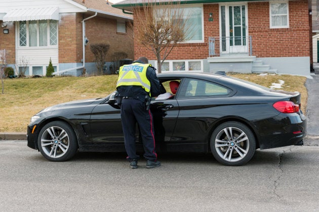 A Toronto Police Service officer giving a speeding ticket to a driver parked on the side of the road on March 9, 2016.