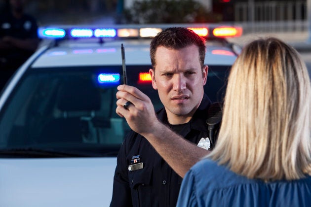 Police officer (20s) conducting sobriety test on woman.