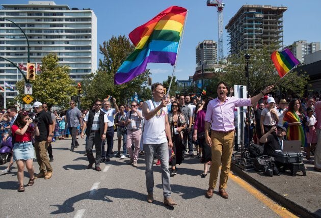 Justin Trudeau, right, and Vancouver mayor Gregor Robertson, centre, march in the Pride Parade in Vancouver, on Sunday August 5, 2018.