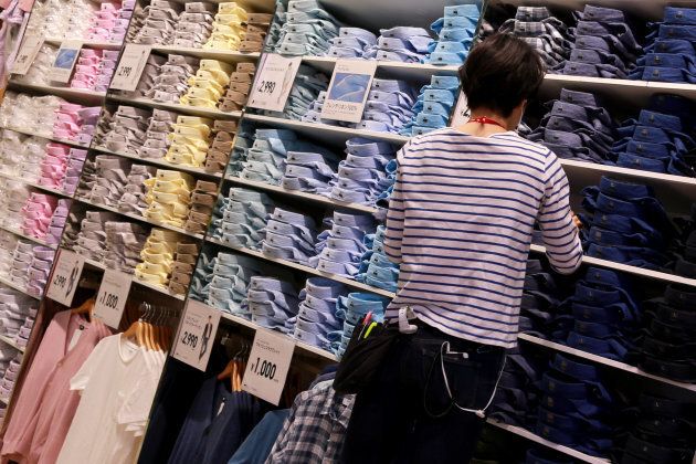 An employee folds shirts on display at the flagship Uniqlo store in Osaka, Japan, on April 11, 2018.