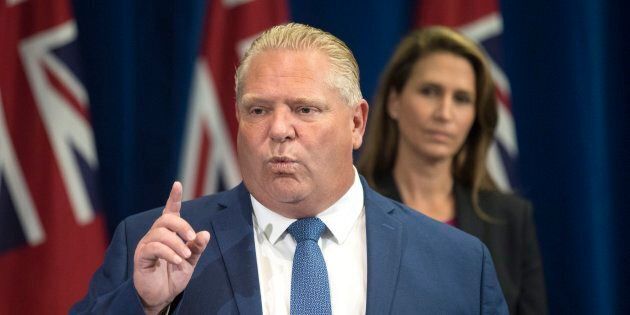 Ontario Premier Doug Ford speaks as Ontario Attorney General Caroline Mulroney looks on during a press announcement at the Queens Park Legislature in Toronto on Aug. 9, 2018.