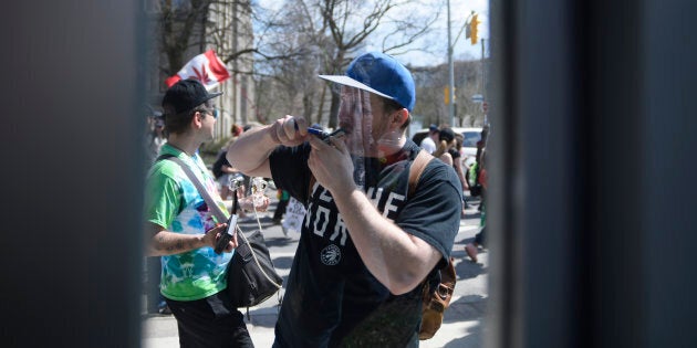 Reflection of a participant lighting a pipe during the Toronto Global Marijuana in spring 2018.