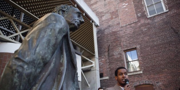 A statue of Sir John A. Macdonald overlooks the Imam at Masjid Al-Iman, Ismail Mohamed Nur, as he speaks during a vigil to honour the victims of a shooting at a Quebec City mosque, in Victoria on Jan. 31, 2017.